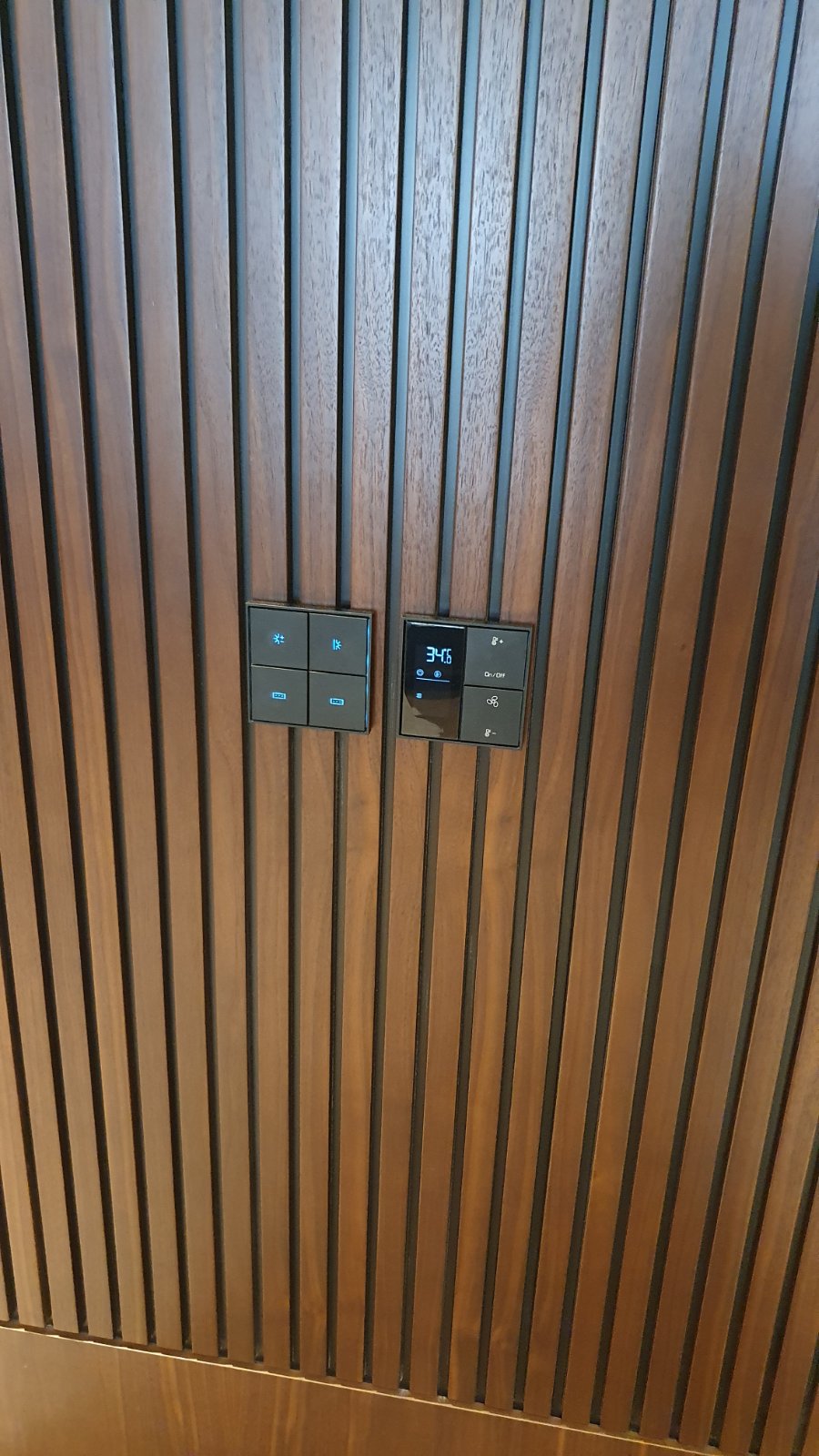 Detalj upravljanja pametnom kućom uklopljen u drvenu oblogu enterijera